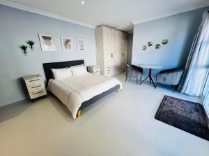 a bedroom with a bed and a table in it at Rissie's Place in Gordonʼs Bay