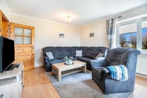 a living room with a couch and a tv at Ferienhof Martens in Schülperweide