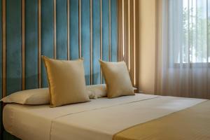 a bed with two pillows on top of it at Case Vacanza Loria in Castelluzzo