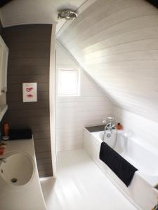 uma casa de banho com um lavatório e uma banheira em Between the dunes and the sea em Les Moitiers-dʼAllonne