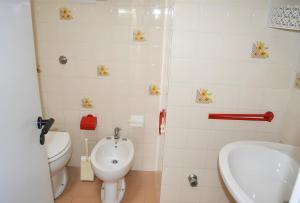 een badkamer met een toilet, een bidet en een wastafel bij Pt63 Casa a T dell Orso con veranda in Melendugno
