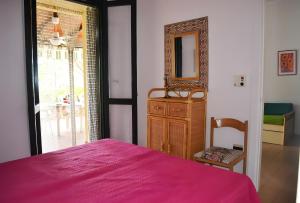 een slaapkamer met een bed, een spiegel en een dressoir bij Pt63 Casa a T dell Orso con veranda in Melendugno