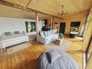 a large living room with a bed and a couch at Casa de pe Lac - La noi la munte in Mătişeşti