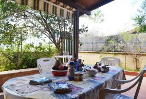 een tafel met een tafelkleed en stoelen op een terras bij Pt63 Casa a T dell Orso con veranda in Melendugno