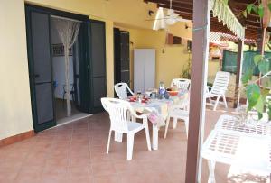 een witte tafel en stoelen op een patio bij Pt63 Casa a T dell Orso con veranda in Melendugno