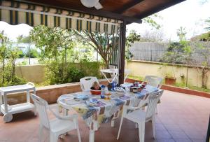 een witte tafel en stoelen op een patio bij Pt63 Casa a T dell Orso con veranda in Melendugno +19 foto's