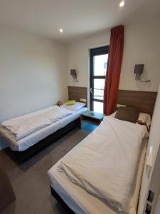 a room with two beds and a window at Marina Strandbad Chalet Land in Sicht mit Zaun Haus Nr 81 in Olburgen +41 photos