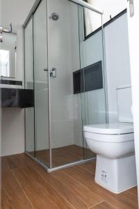 Un baño con inodoro y ducha de cristal. en Guaja 745 - Apartamento Bento, en Belo Horizonte