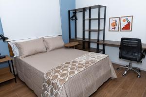 Un dormitorio con una cama, un escritorio y una silla. en Guaja 745 - Apartamento Bento, en Belo Horizonte 5 fotos más