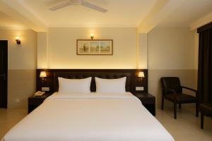 Un dormitorio con una gran cama blanca y una silla. en ECKO Antarman On The Ganges, en Haridwar 153 fotos más