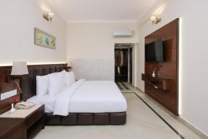 una habitación de hotel con una cama y un televisor en ECKO Antarman On The Ganges, en Haridwar