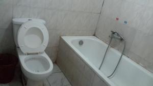 a bathroom with a toilet and a bathtub with a shower at Affta Inn in Addis Ababa +21 photos