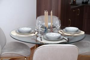 a dining room table with plates and glasses and candles at Birkin Casa- Prime Location in Novi Sad