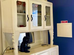 a white cabinet with glass doors on top of a counter at Casa das Histórias in Pinhel