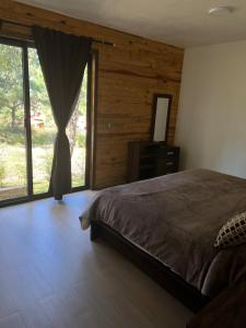 a bedroom with a bed and a large window at Cabaña Casa Carolina in Mazamitla