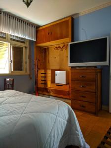 a bedroom with a bed and a flat screen tv at Pousada Cyprianos in Júlio de Castilhos +25 photos