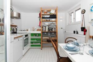 a kitchen with white cabinets and a table with chairs at Boutique House Anni in Piran