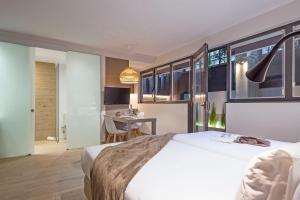 a bedroom with a white bed and a desk in a room at Aparthotel Bcn Montjuic in Barcelona +76 photos
