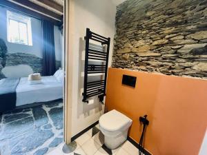 a bathroom with a toilet and a stone wall at Casa Sarvaega in Cogorno +40 photos