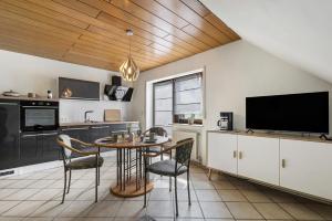 a kitchen with a table and chairs and a tv at Gerda Ferienwohnung in Weigendorf +7 photos