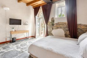 a bedroom with a bed and a desk and a television at Casa Sarvaega in Cogorno