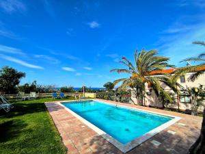 达拉索Villa Koulouridi Agritourism的院子里有一棵棕榈树，院子里有一个游泳池