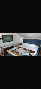 a bedroom with a bed with a blue head board at Casa del Mare in Ulcinj
