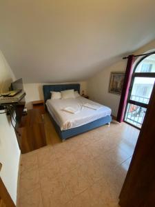 a bedroom with a bed and a desk and a window at Casa del Mare in Ulcinj