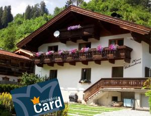 budynek z skrzyniami kwiatowymi na balkonie w obiekcie Haus Schneeberg mit Hochkönig Card w mieście Mühlbach am Hochkönig