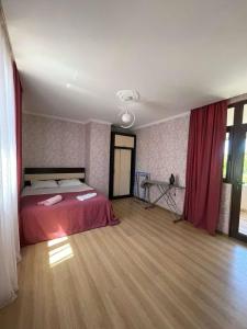 1 dormitorio con 1 cama en una habitación con cortinas rojas en Private House, Apartment, en Itʼkhvisi