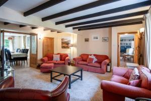 un soggiorno con divani rossi e tavolo di Bullcroft - 6 Bedroom House - Oxwich a Swansea