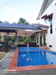 une piscine devant une maison dans l'établissement Villa Gong Badak, Kuala Terengganu, à Kuala Terengganu