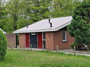 a red brick house with a black door at Robbenoort 45 in Lauwersoog
