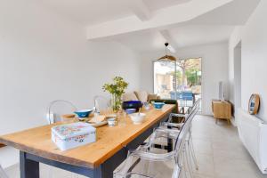 a dining room with a wooden table and chairs at À 220m de la plage, maison avec jardin pour 4 in Le Grand Vieil +9 photos