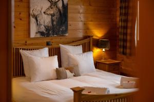 a bedroom with a bed with white sheets and pillows at Chalet Chafrebelle - sauna & view in Nendaz