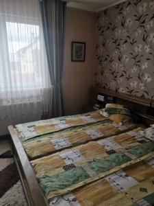 a bed with a quilt on it in a bedroom at Sólyom Katalin vendégház in Văleni