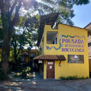 a yellow building with a sign for a restaurant at Pousada Boiçucanga in São Sebastião