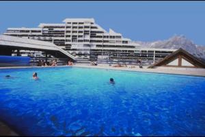 a large swimming pool with people in a large building at Enjoy in Puy-Saint-Vincent