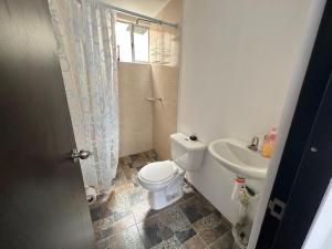a bathroom with a toilet and a sink at Casamora girardot in Estación El Salto +3 photos