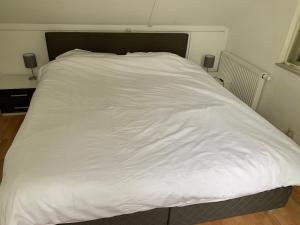 a large white bed in a small room at Vosseveen 62 in Zelhem