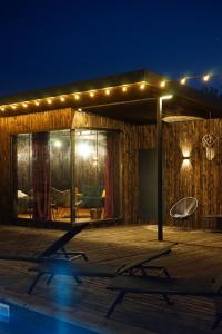 a house with lights and a swimming pool at night at Долина ХЮГГЕ in Chornomors'ke