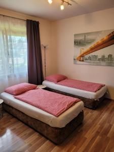 dwa łóżka w pokoju z czerwoną pościelą w obiekcie Zentral gelegene, sehr ruhige und helle Wohnung w Grazu