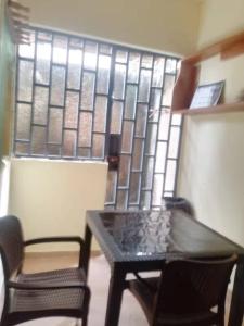 Una mesa y dos sillas frente a una ventana. en Havre de tranquilité, en Yamoussoukro