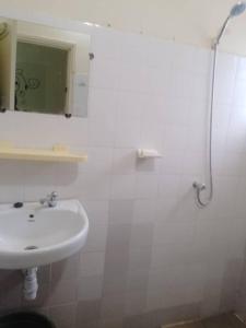 Un baño blanco con lavabo y ducha. en Havre de tranquilité, en Yamoussoukro
