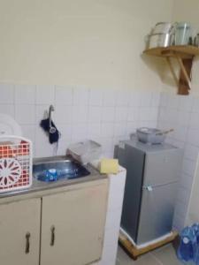 Una pequeña cocina con fregadero y refrigerador. en Havre de tranquilité, en Yamoussoukro