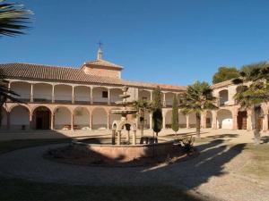 un grande edificio con palme di fronte di Casa Rural Los Galanes a Villanueva de los Infantes