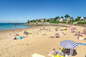 a group of people on a beach with an umbrella at Le 5, loc studio malouin in Saint Malo