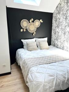 a bedroom with a white bed with a black wall at Le 5, loc studio malouin in Saint Malo