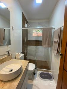 a bathroom with a sink and a toilet and a shower at Chácara Vista da Mata in Marechal Floriano +8 photos