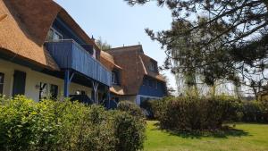 a house with a blue building and some bushes at Lütt Wieck App Nr 12 in Wieck